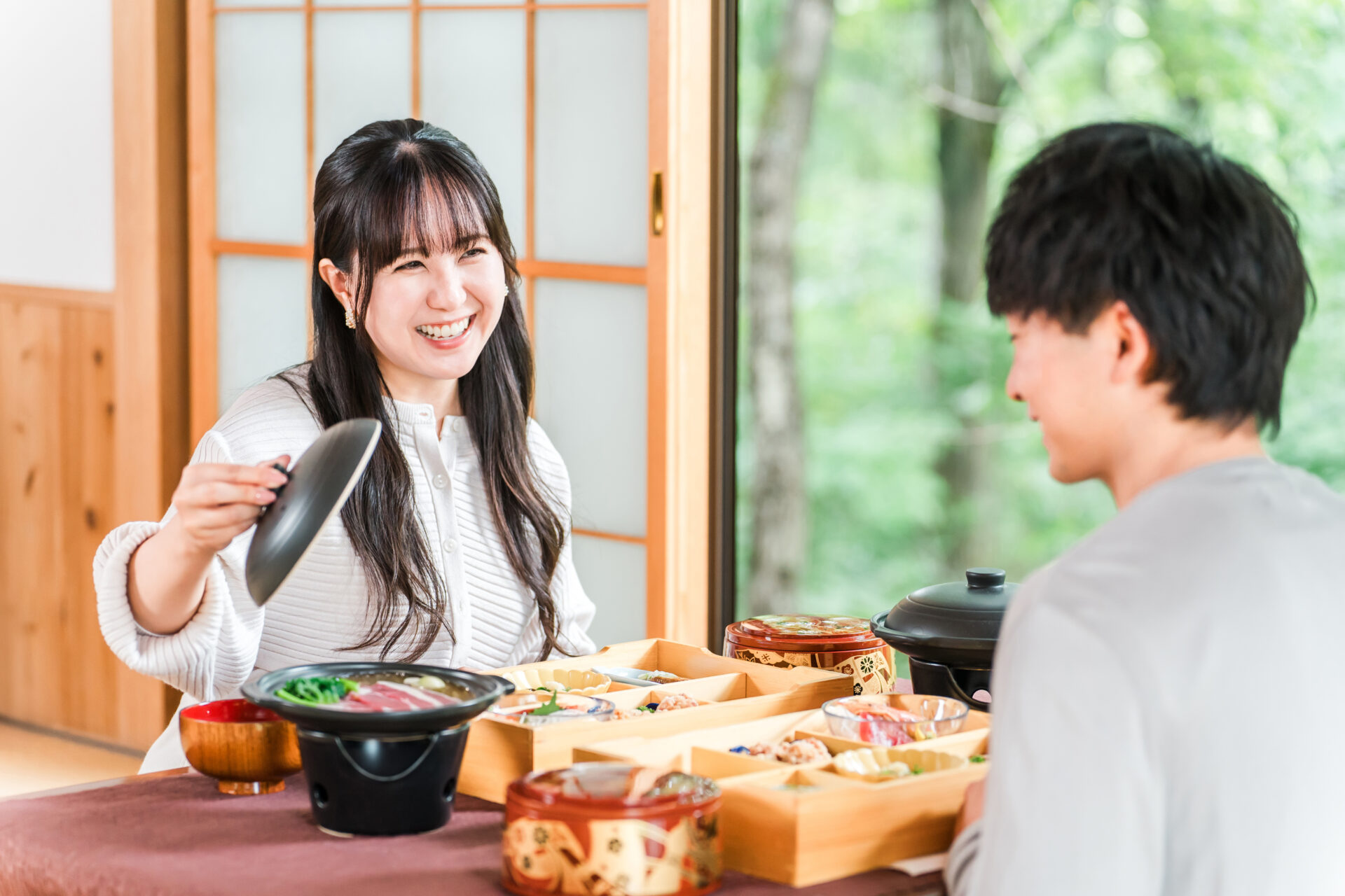 和室で会席料理を楽しむ宿泊客