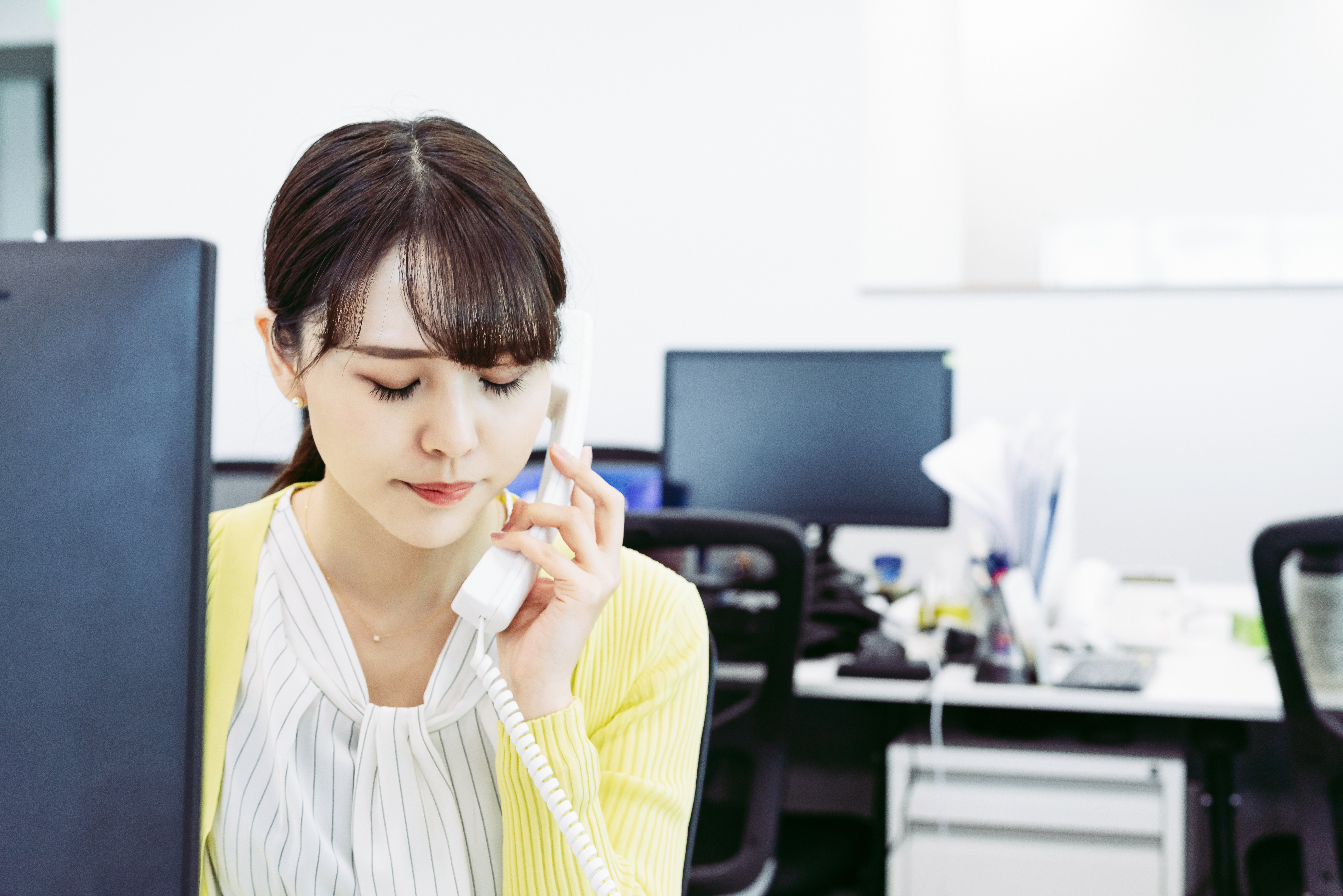 長時間の電話対応で消耗するスタッフ