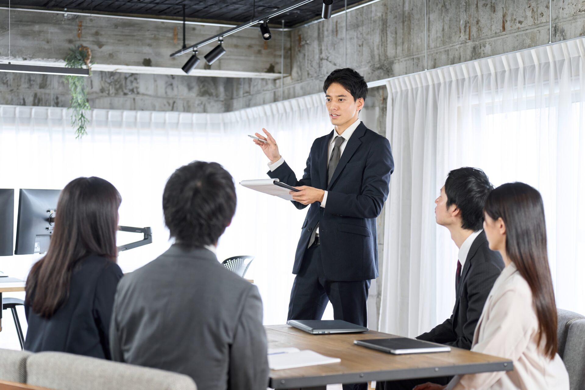 新入社員に研修をするビジネスパーソン