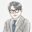 黒縁眼鏡をかけ、グレーのスーツに青いネクタイを締めた男性コンサルタントのイラスト